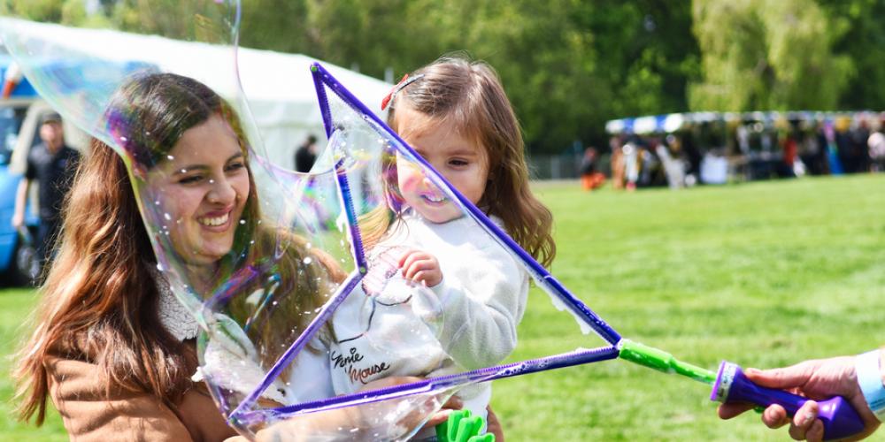 Photo of mother and daughter enjoying a large bubble at a fun day